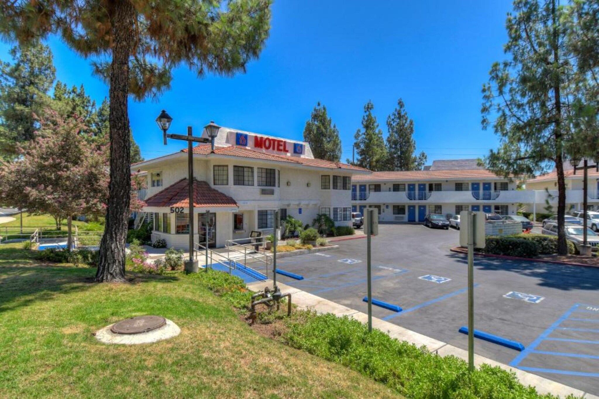 A motel with a parking lot and a building with a red 'Motel' sign.