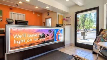 A hotel reception area with a sign that reads 'We'll leave the light on for you.'