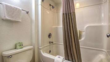 A bathroom with a toilet, a shower with a curtain, and a towel rack.