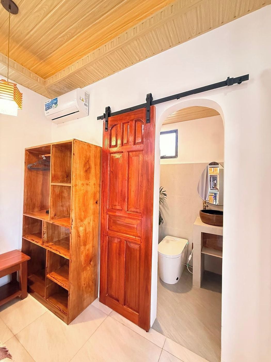Une pièce avec une porte en bois, une porte coulissante de style grange et un mur blanc.