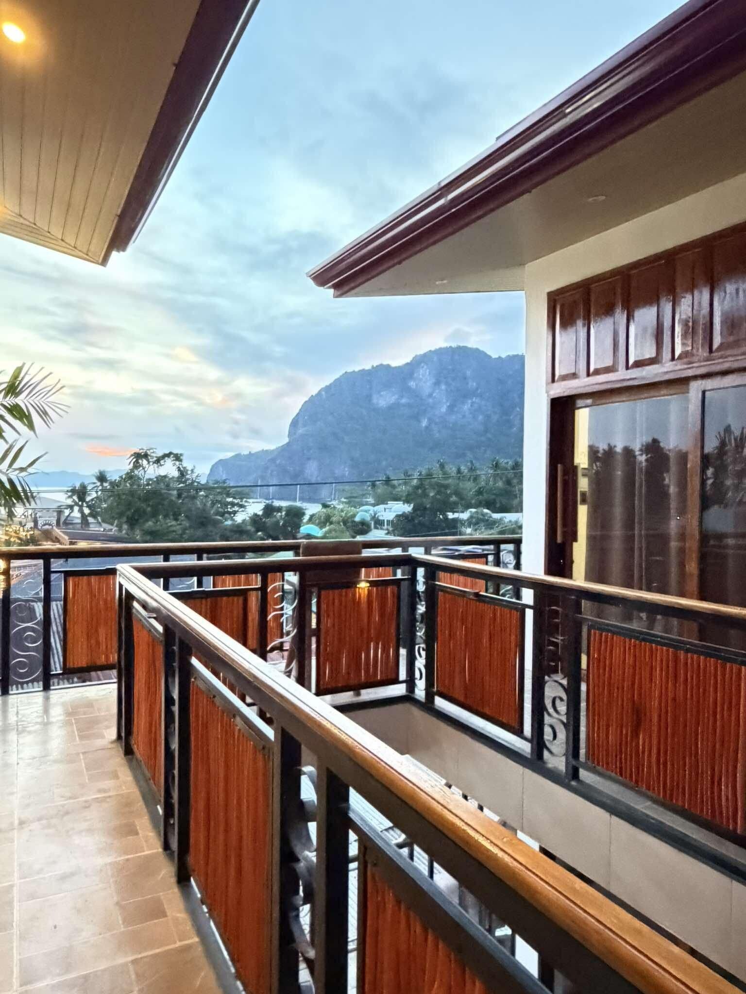 Uma varanda com vista para montanhas e um corpo de água.