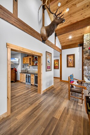 A spacious room with a high ceiling, wooden beams, and a mounted deer head. - The Cascade Ranch House | 24 Acres of Idaho Mountain Country (Cascade)
