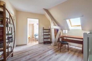 A loft bedroom with a sloped ceiling, a wooden desk, a chair, a ladder, and a bookshelf. - Le Clos de Marsannay –4-Bedroom House (Marsannay-la-Côte)