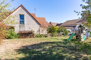 A residential area with houses, a grassy yard, and a children's play area with a slide. - Le Clos de Marsannay –4-Bedroom House (Marsannay-la-Côte)