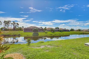 Ein Wohngebiet mit Teich, Häusern und blauem Himmel.