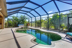 Ein überdachter, schwungvoll gestalteter Pool, umgeben von einer Glaskonstruktion, sowie eine Terrasse mit Whirlpool.