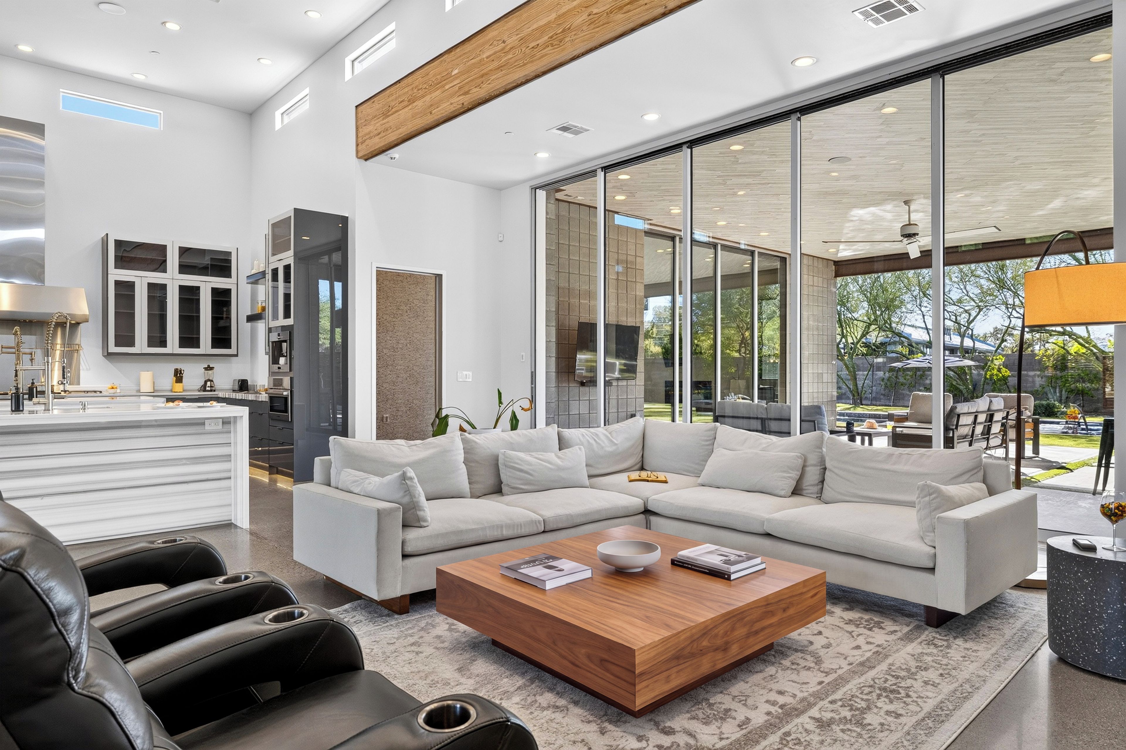 A modern living room with a sectional sofa, a coffee table, and a view of the outdoors.