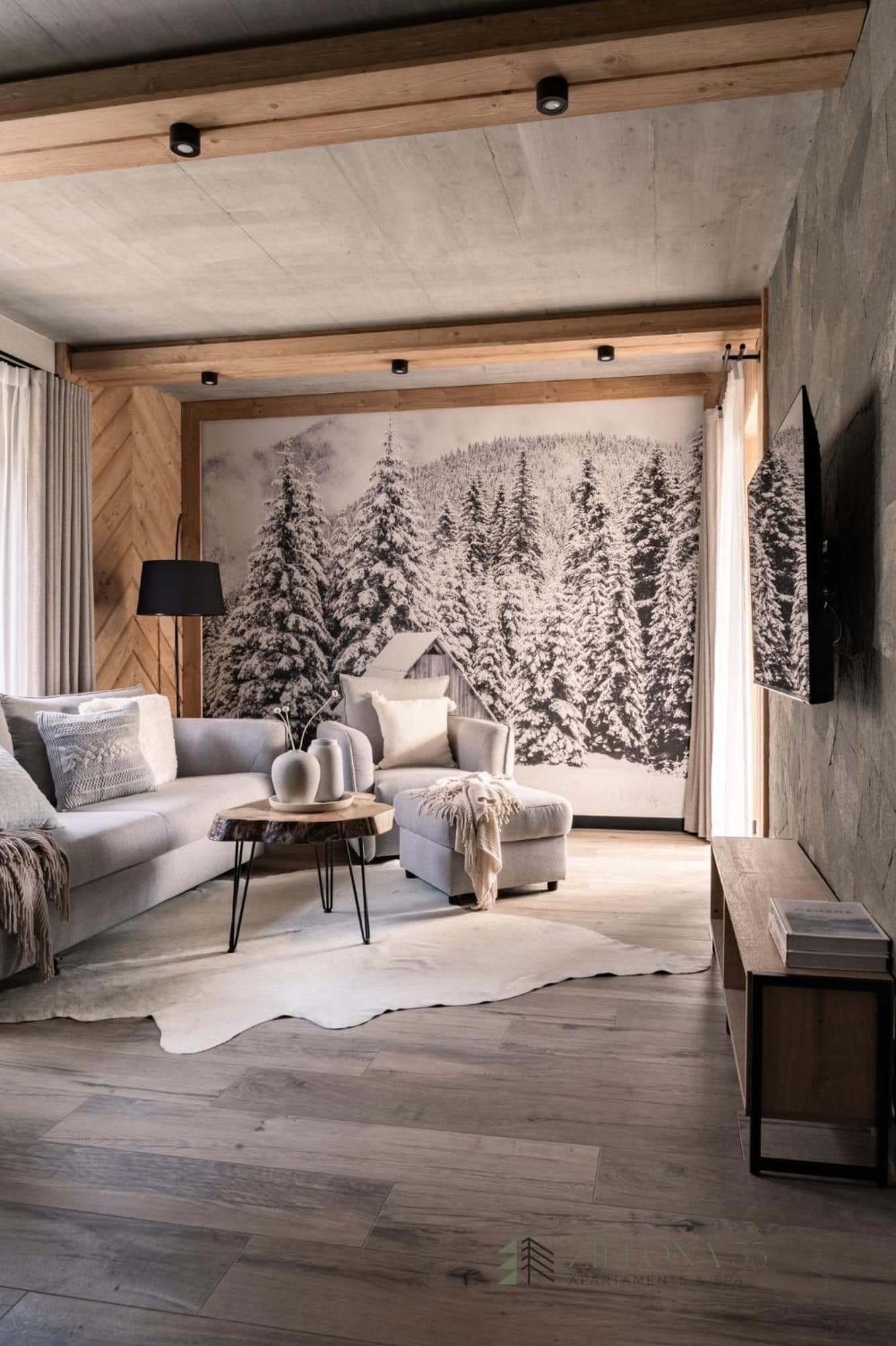 Una sala de estar moderna con un mural grande en la pared, un sofá, una mesa de centro y una alfombra.