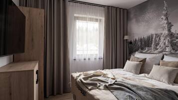 Un dormitorio con cama, cortinas, un cuadro y televisor.