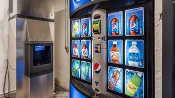 Een automaat met diverse drankjes, waaronder Pepsi, M&Ms, Aquafina water en Squirt.