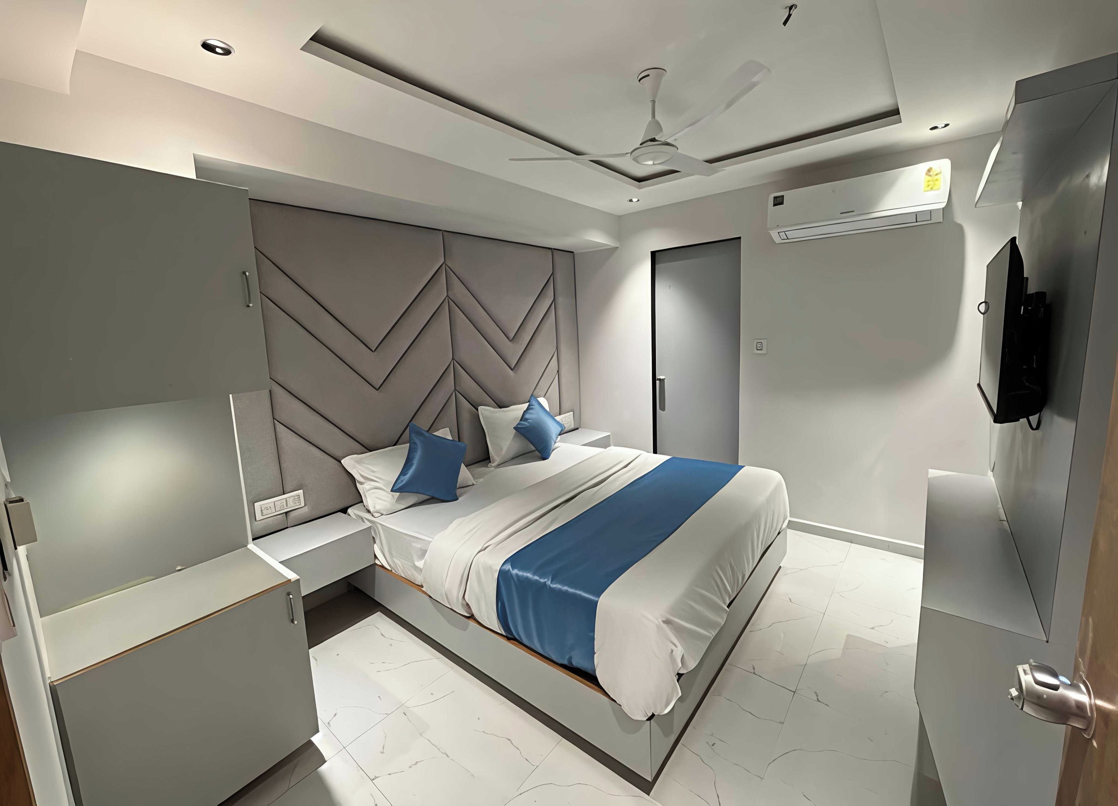 A modern bedroom with a bed, bedside tables, a wardrobe, and a ceiling fan.