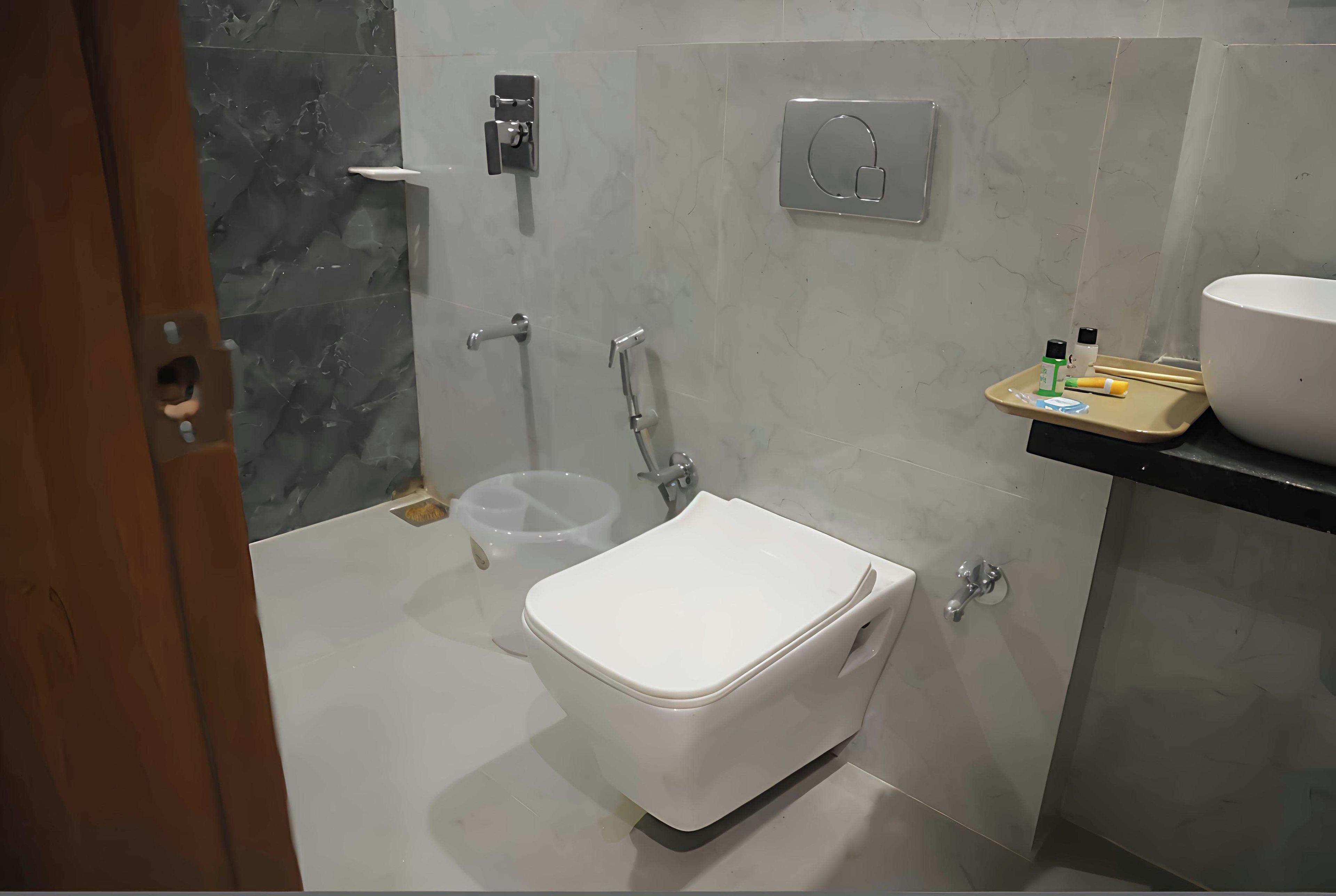 A modern bathroom with a toilet, a shower, and a sink.