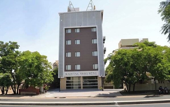 A modern multi-story building with a flat facade, large windows, and a sign indicating it is a hotel.