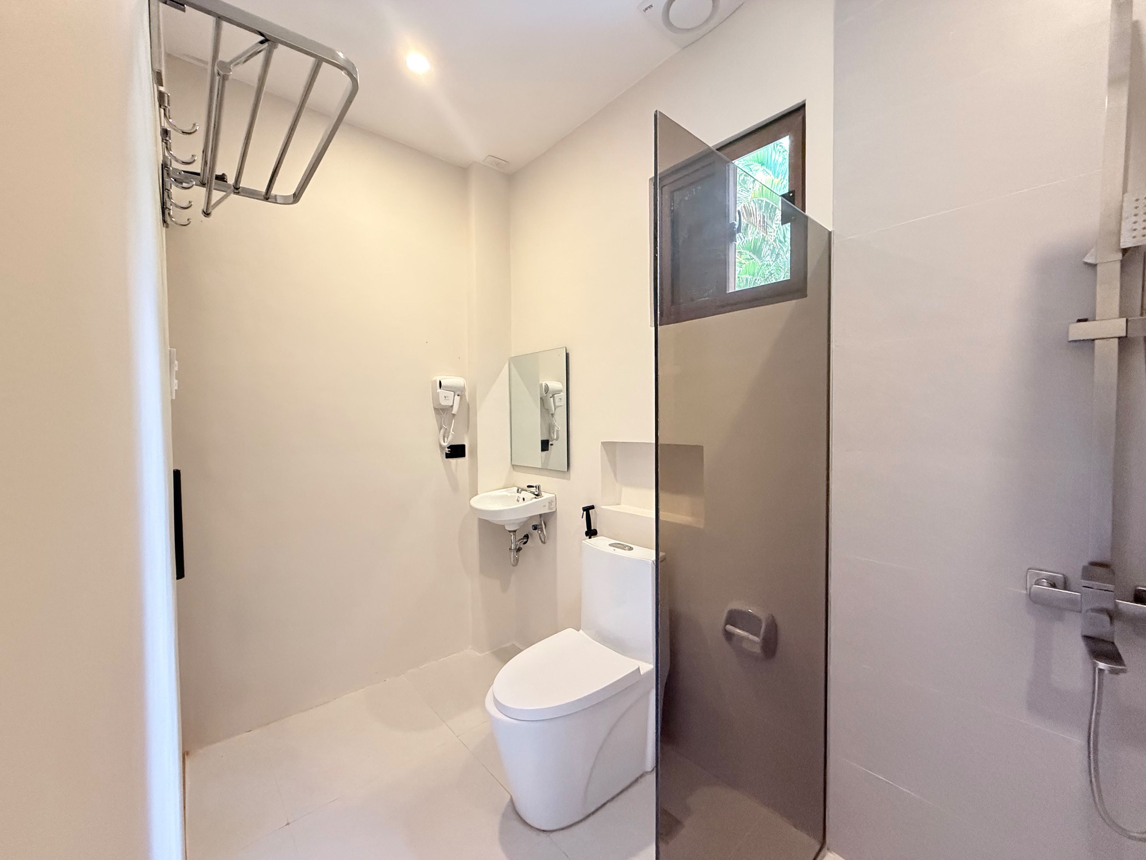 A modern bathroom with a toilet, sink, and shower.