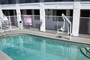 A swimming pool with a fenced area, a chair, and a sign indicating a diving area. - 1 King Bed|Mobility|Tub,Nsmk (Fresno CA)