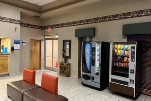 A lobby with seating, vending machines, and a reception desk.