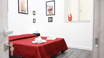 Ein Hotelzimmer mit Bett, Fenster und Bildern an der Wand.