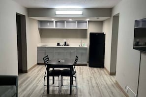 Una cocina compacta con una mesa y sillas, un refrigerador y un horno empotrado.
