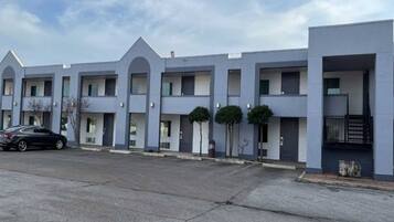 A row of modern, multi-story buildings with a uniform architectural style, featuring balconies and a flat roof.