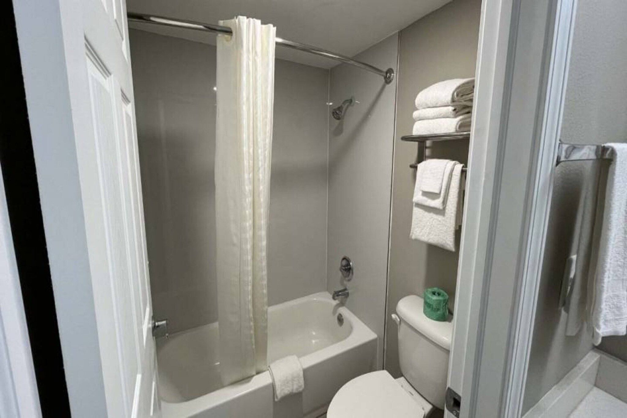 A bathroom with a bathtub, toilet, and a shower curtain.