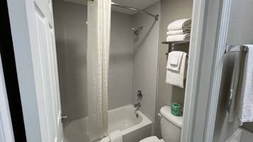 A bathroom with a bathtub, toilet, and a shower curtain.