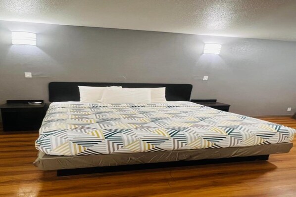 A bedroom with a bed, two bedside tables, and a headboard.