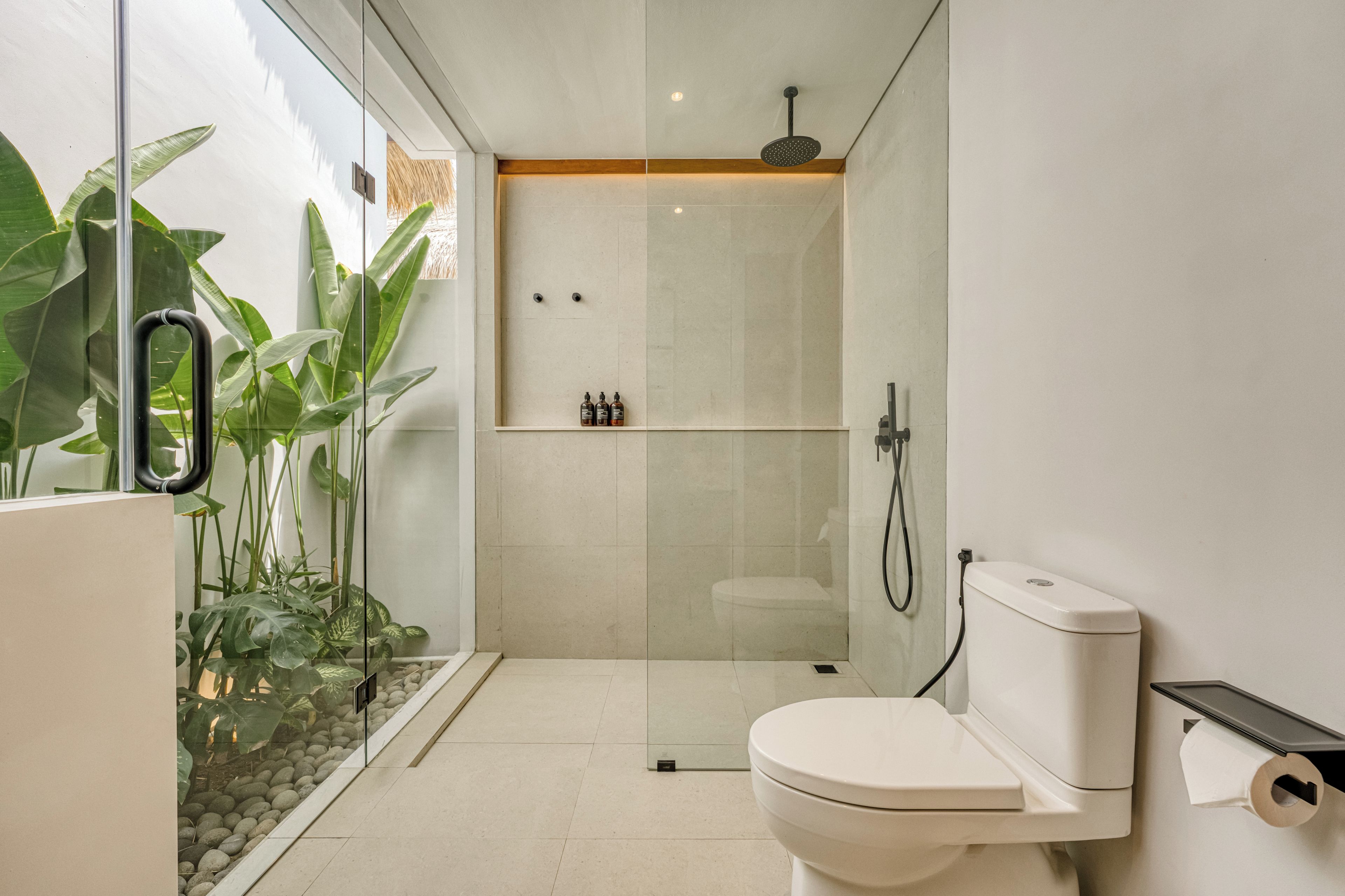 Une salle de bain moderne avec une douche à parois de verre, des toilettes et un lavabo.