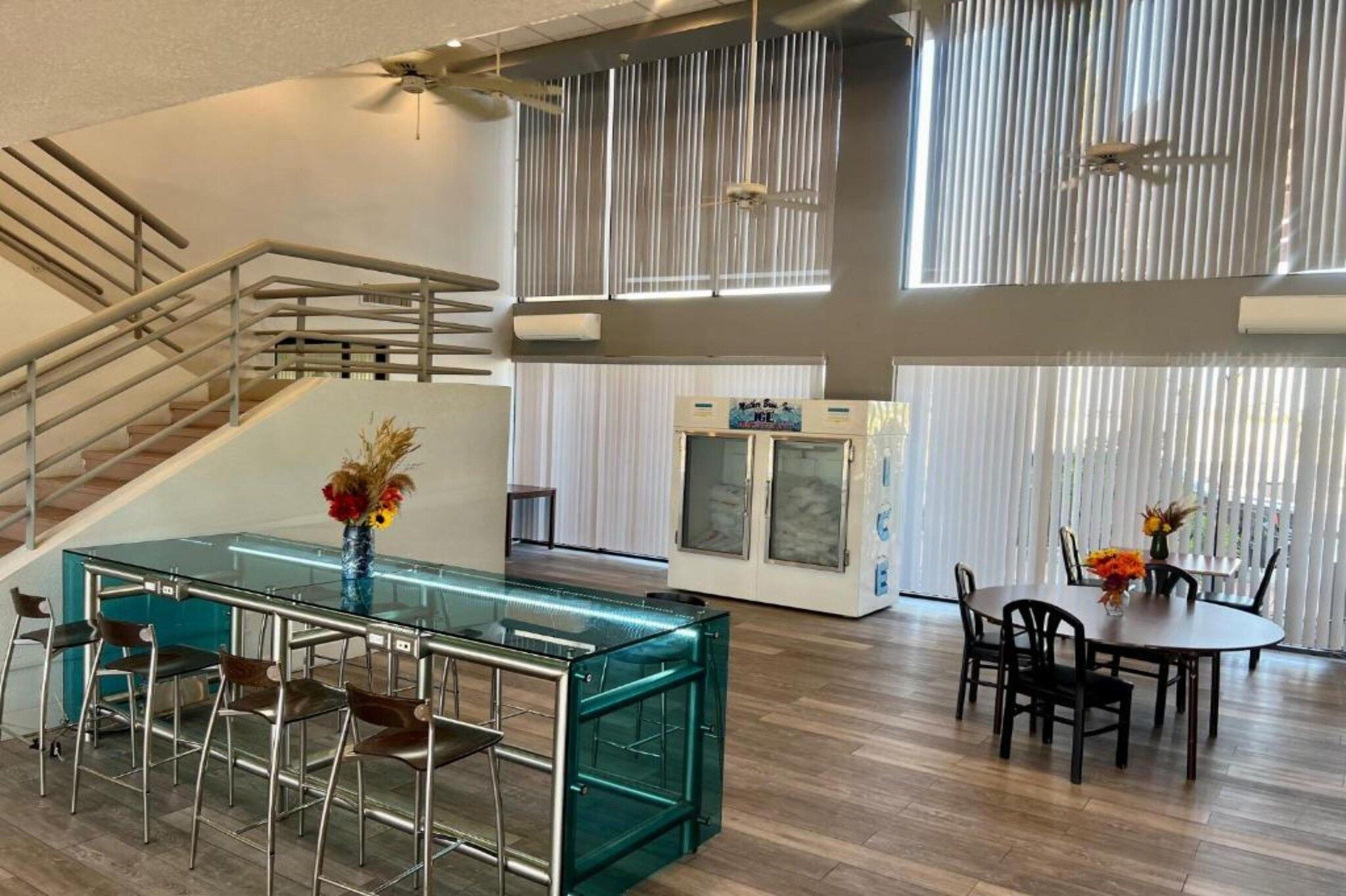 A modern interior with a glass-top bar, seating area, and a staircase.