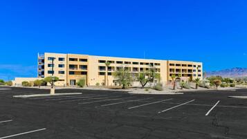A multi-story hotel with a parking lot in front.
