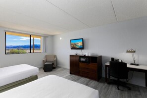 A hotel room with a bed, a desk, a chair, a TV, and a view of a mountainous landscape. - 2 Queen Beds | Non-Smoking, Micfridge (Lake Havasu City)