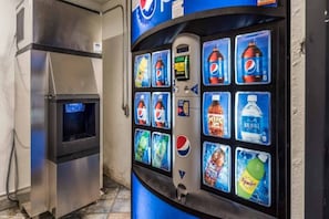 Een automaat met diverse drankjes, waaronder Pepsi, M&Ms, Aquafina water en Squirt.