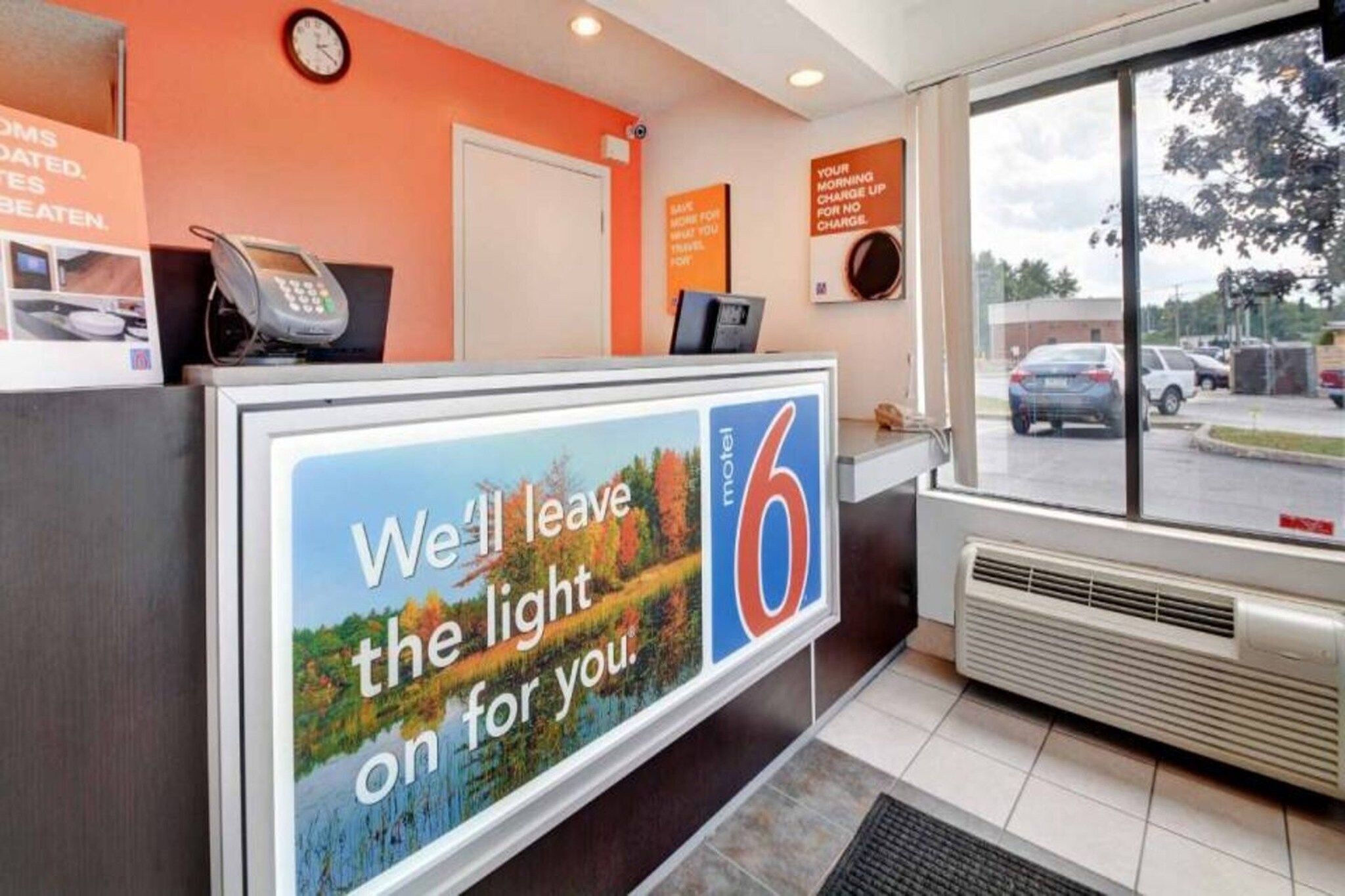 A motel reception desk with a large sign advertising the motel's services.