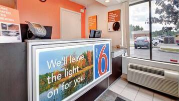 A motel reception desk with a large sign advertising the motel's services.