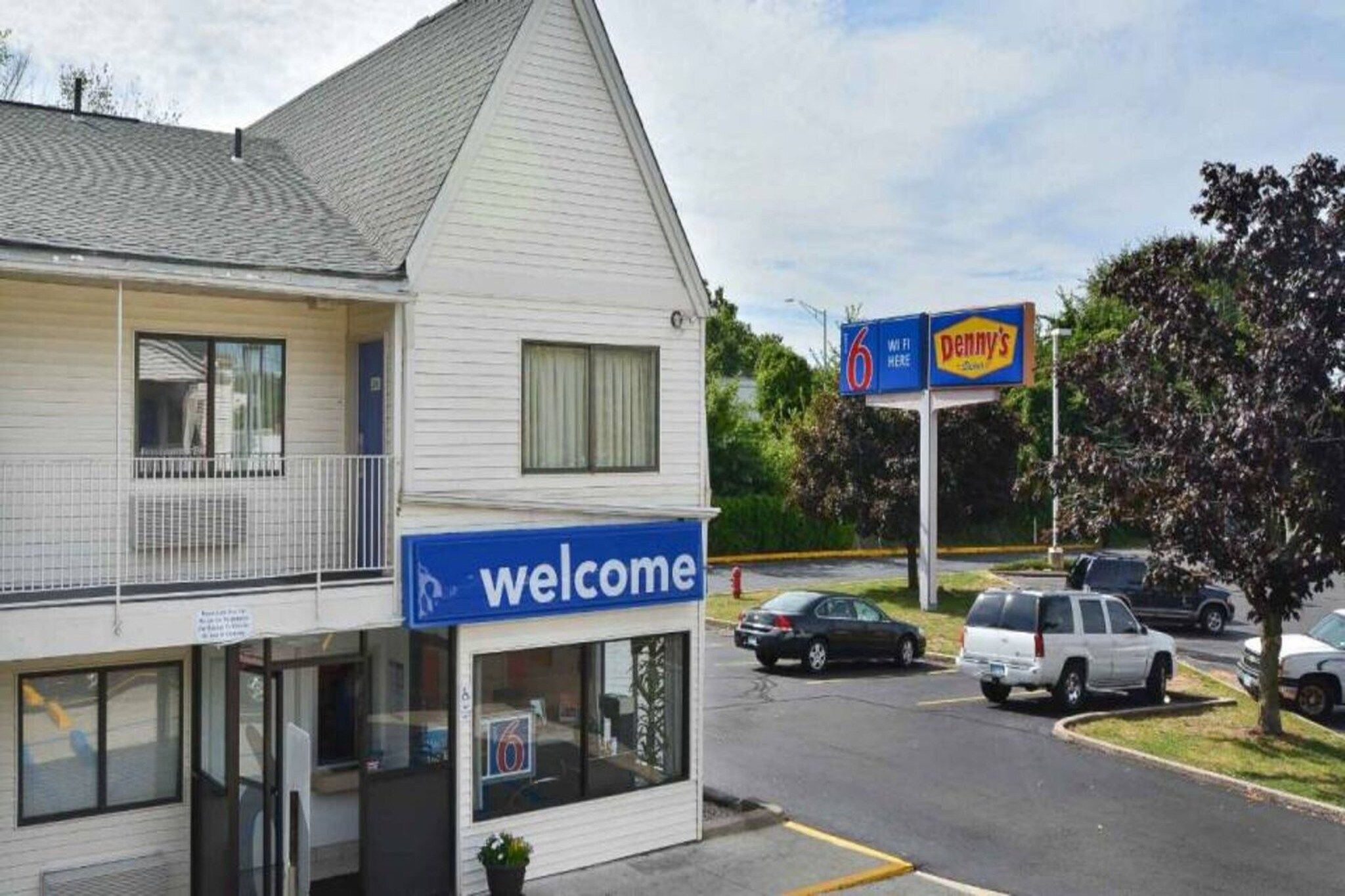 A two-story building with a 'Welcome' sign, a parking lot, and a 'Penny's' sign in the background.