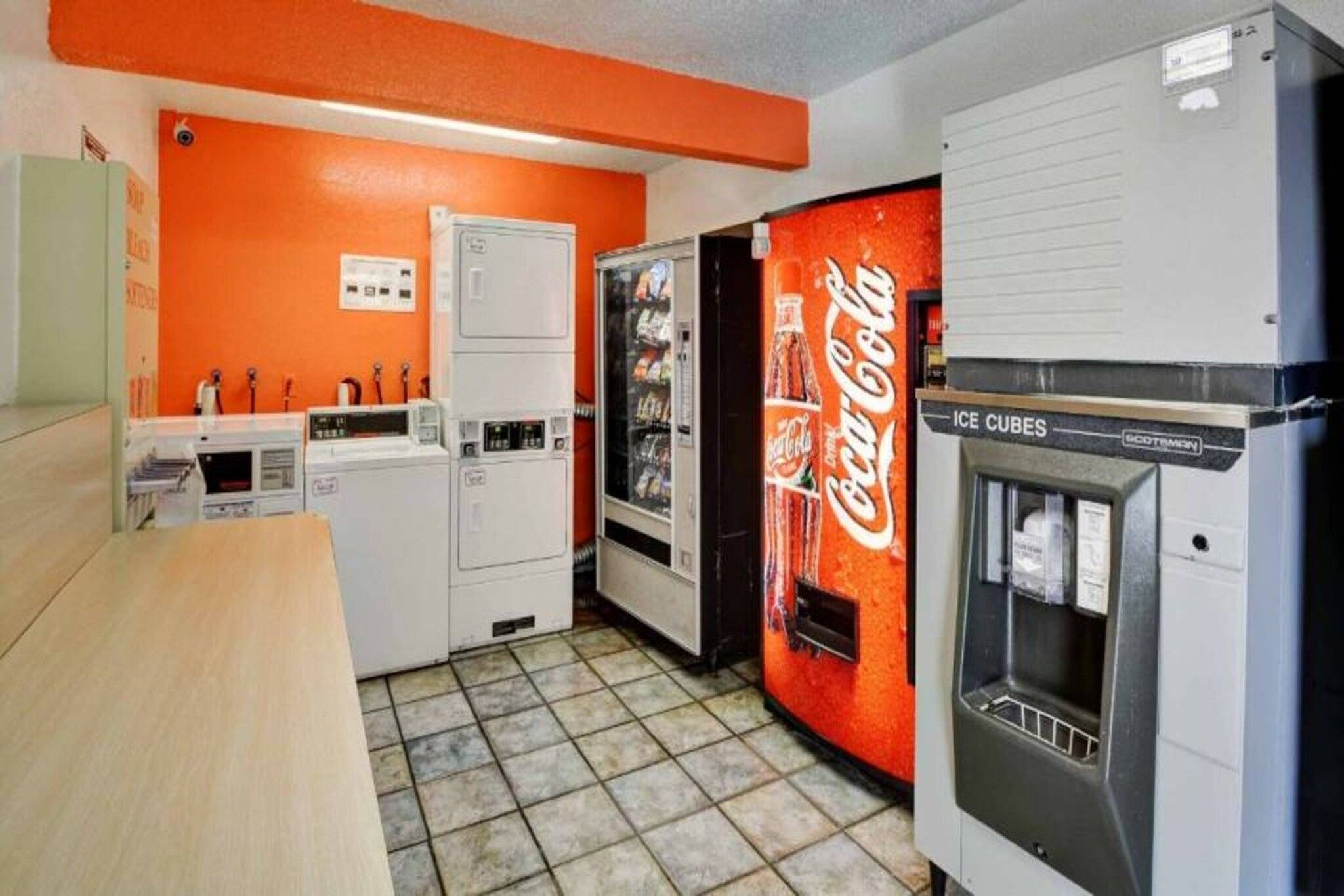 A kitchen with a refrigerator, a vending machine, and a water dispenser.