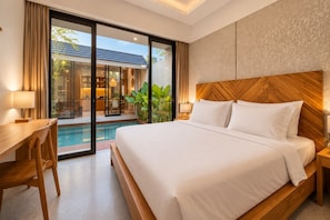 A hotel room with a large bed, a desk, and a view of a swimming pool. - Villa Sora by Kelle, Ubud (Gianyar)