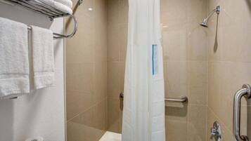Ein Badezimmer mit Dusche, Haltegriffen und Handtuchhalter.