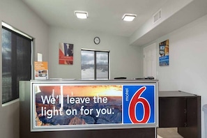 A motel reception desk with a large sign reading 'We'll leave the light on for you.' - 1 King Bed | Non-Smoking, Micfridge (Show Low)