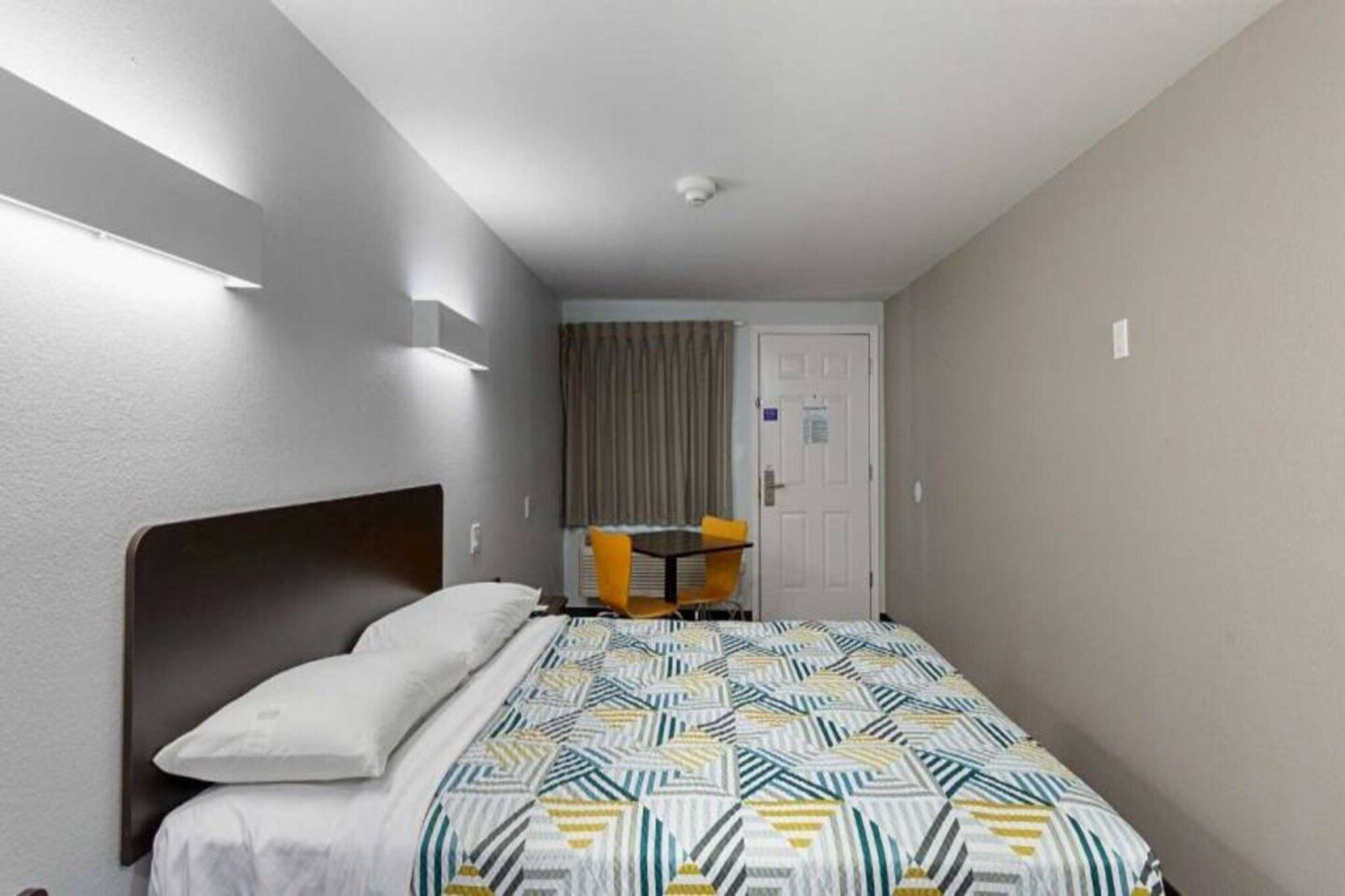 Ein Hotelzimmer mit einem Bett, einem Schreibtisch und einem Stuhl.