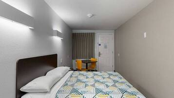 Ein Hotelzimmer mit einem Bett, einem Schreibtisch und einem Stuhl.