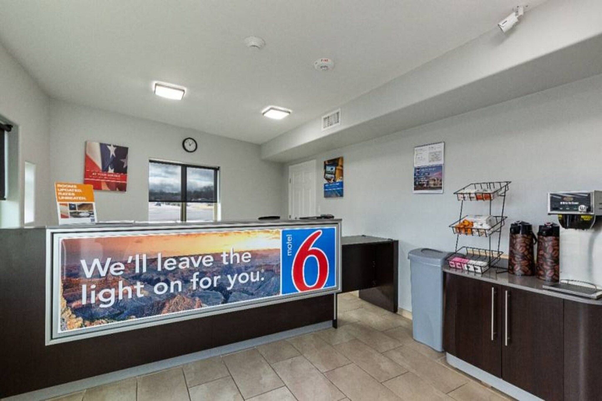 A reception area with a counter, a clock, and a window.
