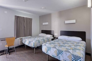 A hotel room with two beds, a desk, and a chair. - 2 Queen Beds | Non-Smoking, Kitchen (Show Low)