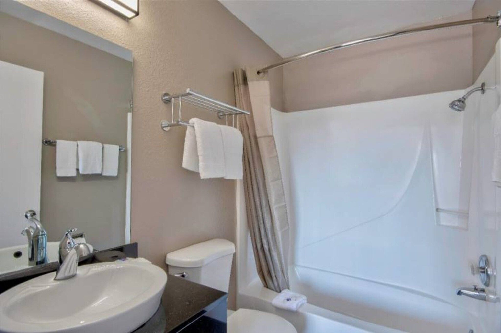 A bathroom with a sink, toilet, and bathtub.