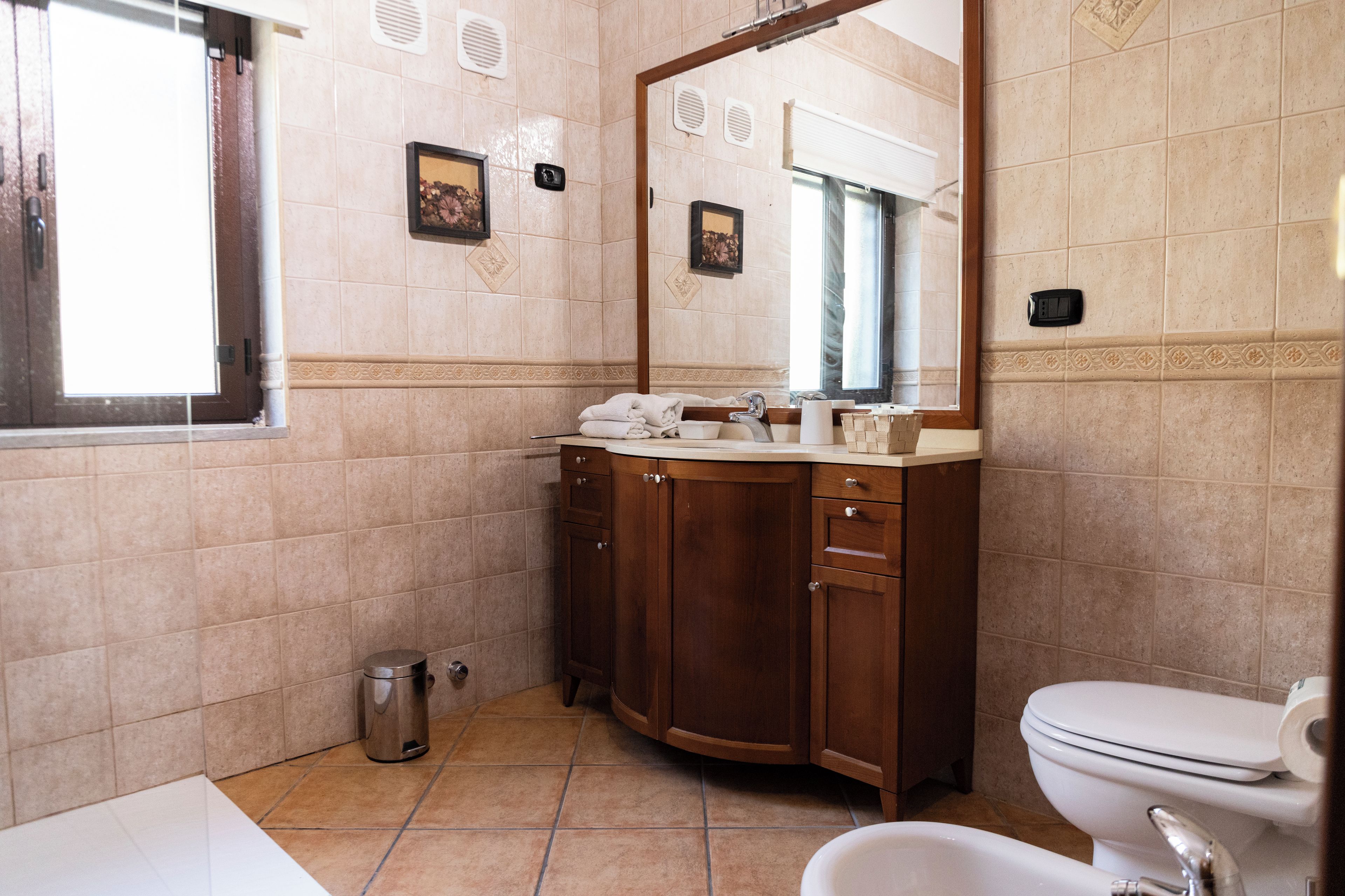 Une salle de bain avec des toilettes, un lavabo et un miroir.