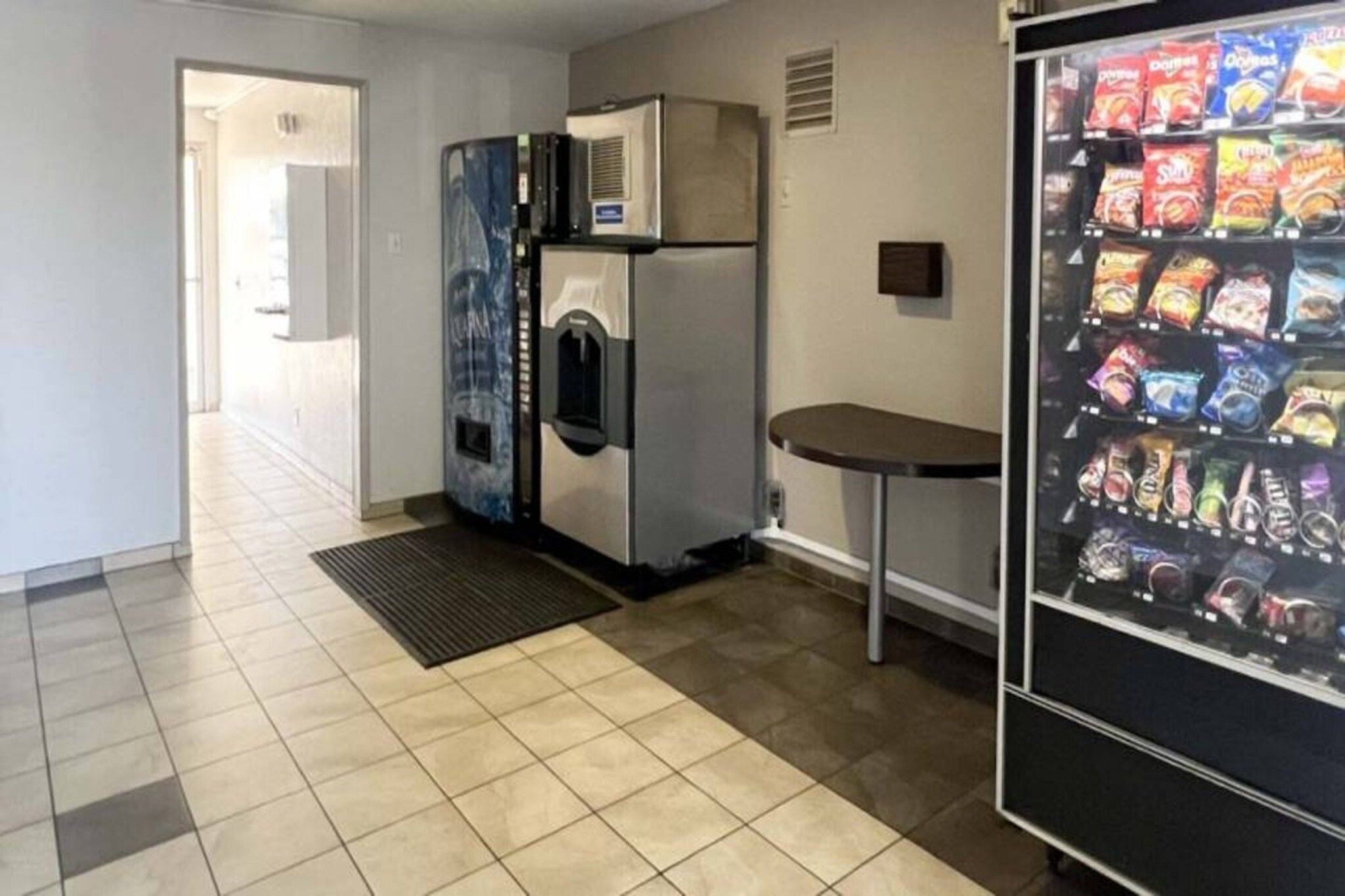 Eine Küchenzeile mit Kühlschrank, Mikrowelle und Getränkeautomaten.