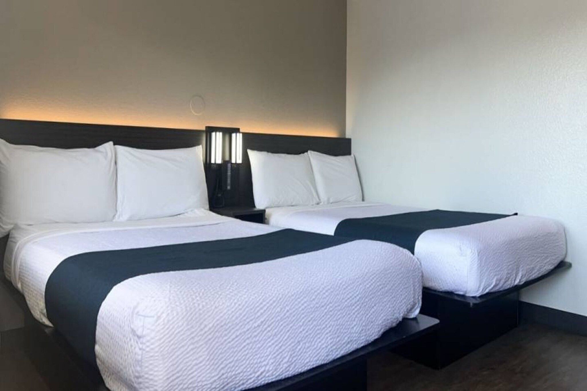 A double bed with a dark headboard and white bedding.