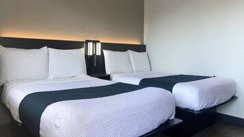 A double bed with a dark headboard and white bedding.