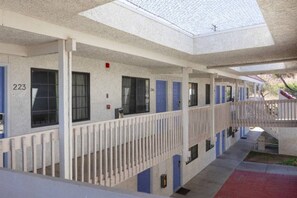 Een motel met afzonderlijke kamers, elk voorzien van een deur en raam, en een overdekte loopbrug.