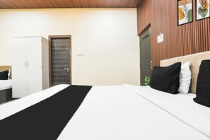 Habitació d'hotel amb llit, un armari, una porta i una paret amb disseny de panells de fusta verticals.