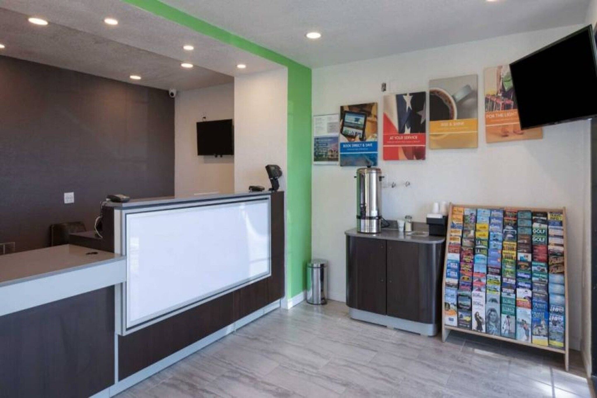 A reception area with a counter, a coffee machine, a trash bin, and a magazine rack.